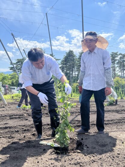 山本町長（左）が最後に土をかぶせて地面を固めている様子