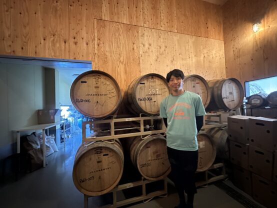 野生酵母の部屋に並んだ木樽と西崎さん